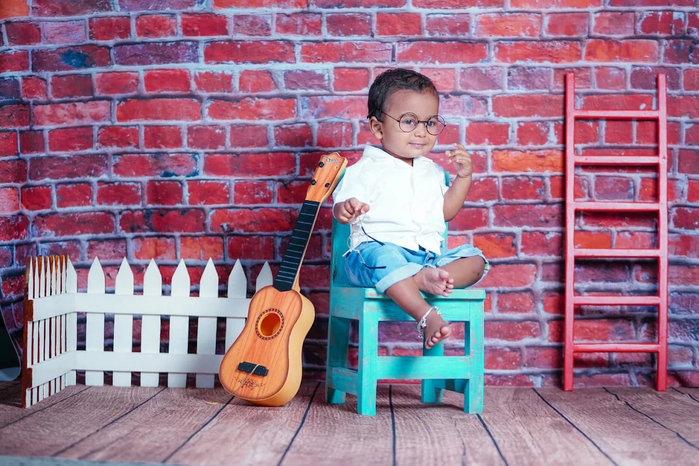Toddler with miniature guitar and turquoise chair